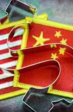 US- und China-Fahne nebeneinader, überdeckt von einem Dollar-Zeichen