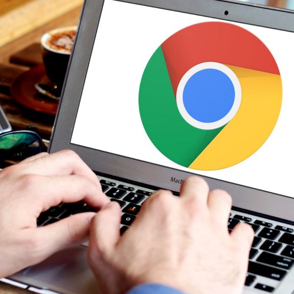 Männerhände bedienen ein Laptop mit Symbol des Google-Browsers auf dem Display