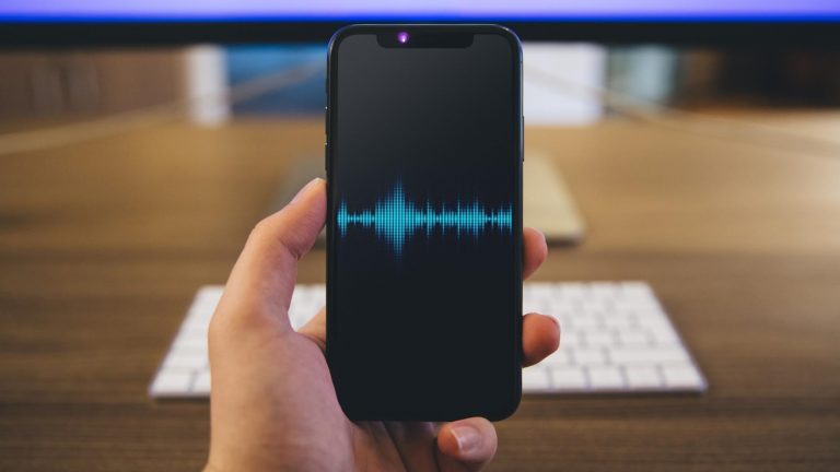 Aufnahme iPhone-Telefonat, symbolisiert durch iPhone X mit oszillierenden Schallwellen auf dem Display