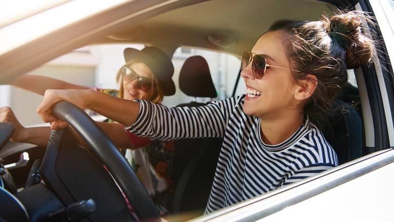 Zwei Freundinnen fahren Auto und haben Spaß Zwei Freundinnen fahren Auto und haben Spaß