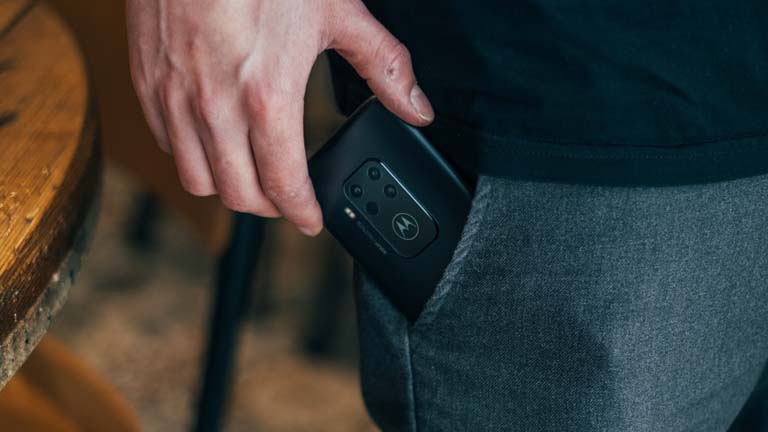 Mann zieht Motorola Handy aus der Hosentasche