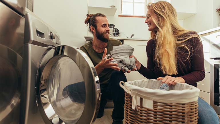 Paar befüllt smarte Waschmaschine