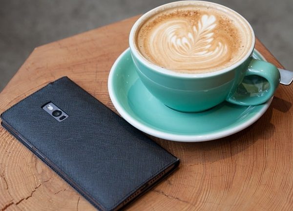 Ein OnePlus-Smartphone neben einer Kaffeetasse