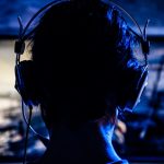 Eine Frau mit Kopfh&ouml;rern nimmt ein Let&rsquo;s Play als Screencast auf