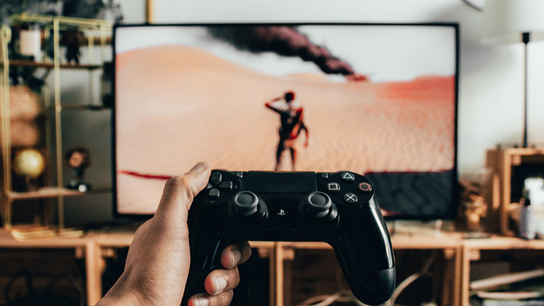 PS4-Controller im Vordergrund und Uncharted 3 auf TV-Bildschirm