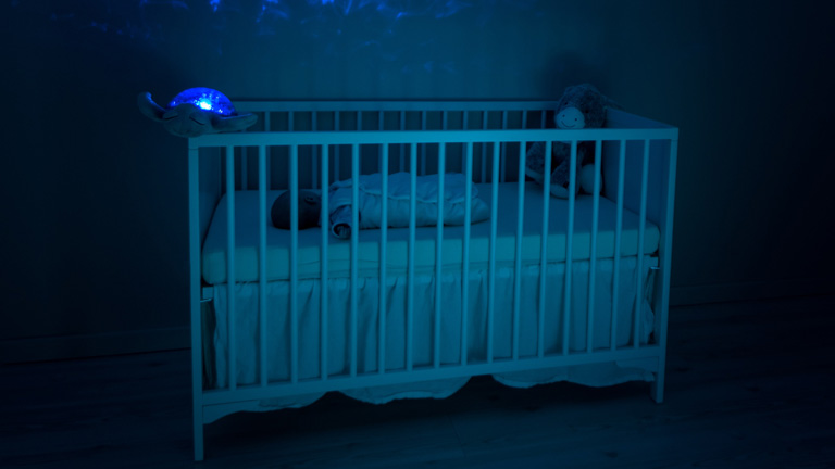 Baby in Babybett mit Nachtlicht