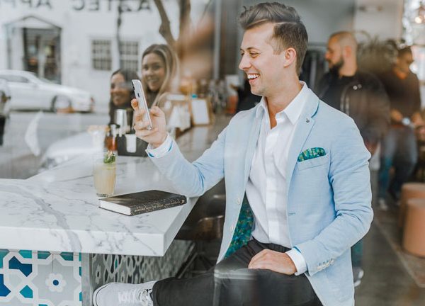 Mann mit Smartphone an Bar