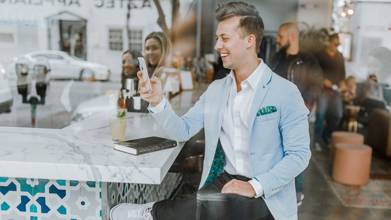 Mann mit Smartphone an Bar