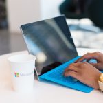Frauenh&auml;nde tippen auf einem blauen Laptop