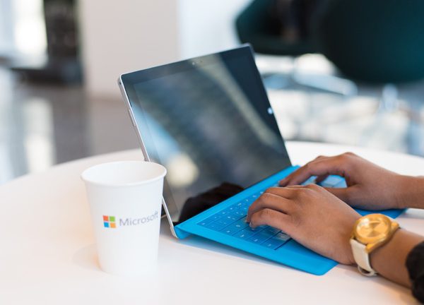 Frauenhände tippen auf einem blauen Laptop