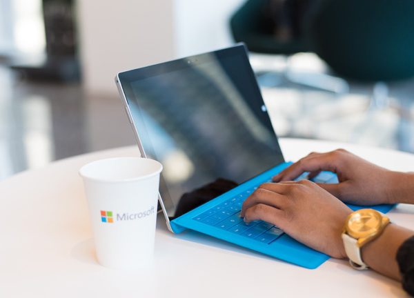 Frauenh&auml;nde tippen auf einem blauen Laptop