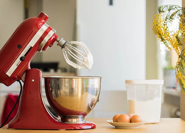 Ein Mixer von KitchenAid steht neben ein paar Eiern auf einem K&uuml;chentisch.