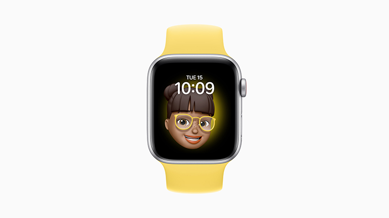 Die Apple Watch SE mit silbernem Gehäuse, Solo-Loop aus Gummi in Gelb und Memoji-Ziffernblatt.