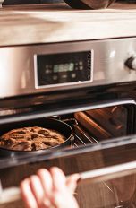 Backofen Eine Person öffnet einen Backofen, in dem ein Kuchen gebacken wird.