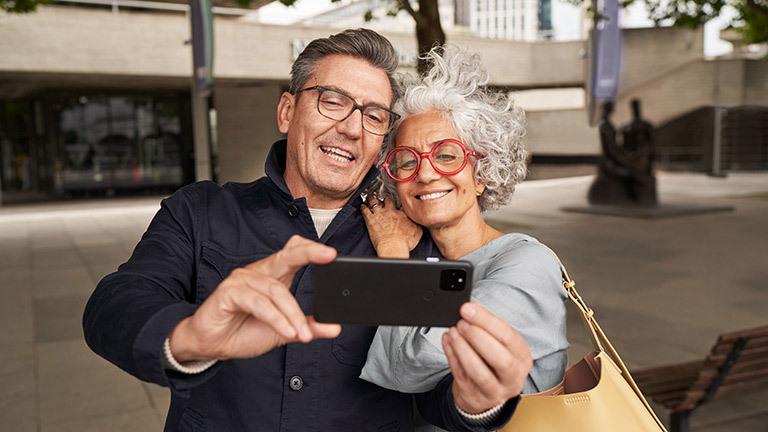 Zwei Personen schauen in die Frontkamera des Google Pixel 5. Dabei sprechen und lächeln sie.