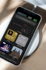 iPhone iOS14 Widgets Ein iPhone auf einer kabellosen Ladestation. Auf dem Bildschirm ist die neue Auswahl der Widgets zu sehen.