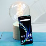 Das OnePlus 8 Pro steht aufrecht angelehnt an eine Gl&uuml;hbirne. Das Display ist aktiviert und zeigt den Home-Bildschirm.