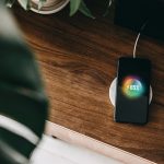 Ein Smartphone liegt auf einer Ladestation und l&auml;dt per Induktion auf.