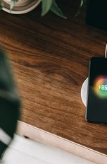 Induktion Ein Smartphone liegt auf einer Ladestation und lädt per Induktion auf.