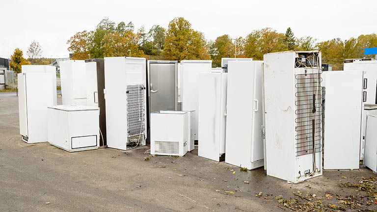 Zahlreiche Kühlschränke stehen auf dem Gelände eines Wertstoffhofs zusammen.