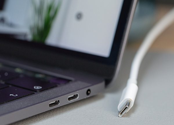 Ein Laptop mit USB-C-Buchse. Daneben ein USB-C-Kabel.