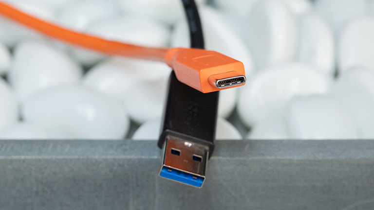 Ein oranges USB-C-Kabel und ein schwarzes USB-A-Kabel.