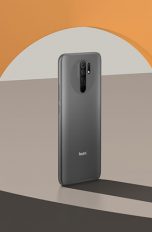Xiaomi Redmi 9 Ein Redmi-Smartphone steht in einem Halbkreis in einer orangefarbenen Wand.