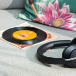 Die Huawei Freebuds Studio auf einem Sofa. Daneben liegt eine Schallplatte.