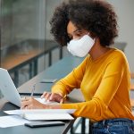 Eine Person tr&auml;gt die PuriCare-Maske von LG, w&auml;hrend sie in einem B&uuml;ro am Laptop arbeitet.