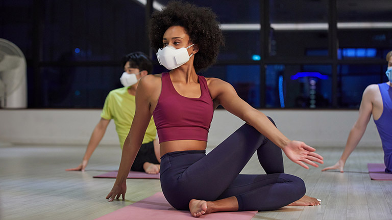 Eine Person trägt die PuriCare-Maske beim Yoga.
