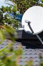 Eine Satellitenschüssel, die auf dem Dach eines Hauses angebracht ist.