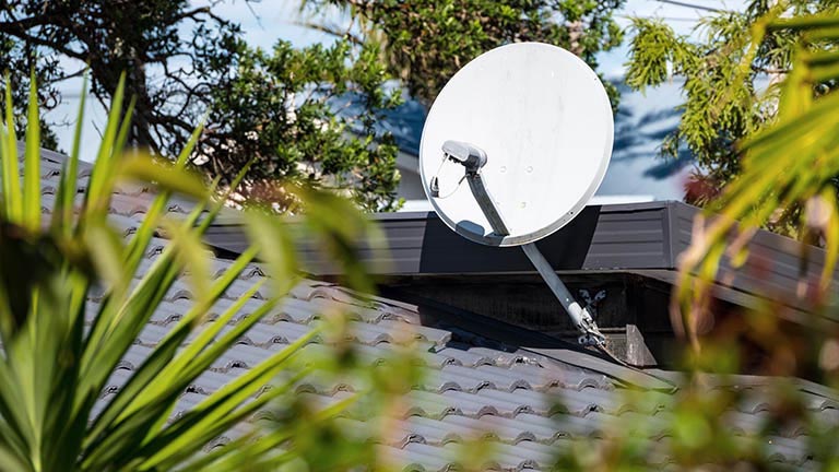 Eine Satellitenschüssel, die auf dem Dach eines Hauses angebracht ist.