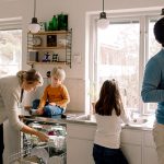 Ein Mann, eine Frau und zwei Kinder befinden sich in der Küche. Die Frau beugt sich über den geöffneten Geschirrspüler.