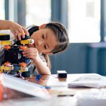 Ein Kind bastelt an einem elektronischen Spielzeug zum Selberbauen.