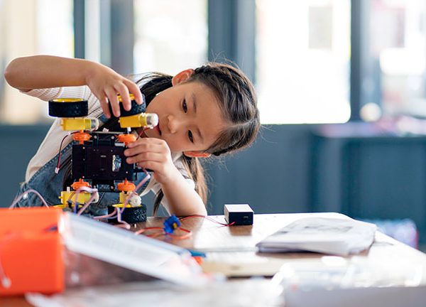 Ein Kind bastelt an einem elektronischen Spielzeug zum Selberbauen.