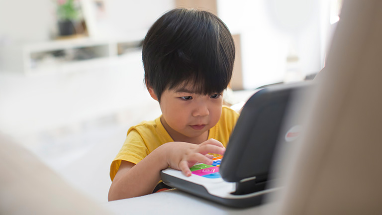 Ein Kind spielt mit einem Laptop für Kinder.
