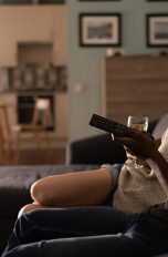 Netflix Passwort ändern Zwei Personen sitzen auf einem Sofa und schauen TV.