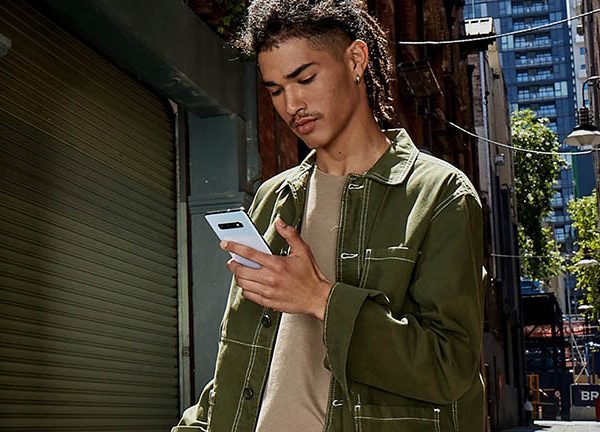 Eine Person h&auml;lt ein Samsung Galaxy S10 in der Hand, w&auml;hrend sie drau&szlig;en unterwegs ist.