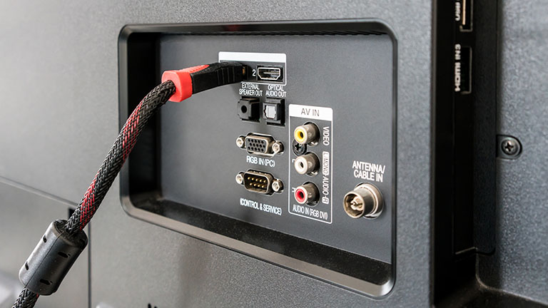 Ein Kabel steckt hinten an einem Fernseher in einem HDMI-Port.