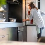 Eine Person &ouml;ffnet den K&uuml;hlschrank und schaut hinein.