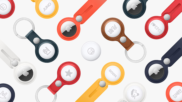 Mehrere Apple AirTags in unterschiedlichen Schlüssel- und Taschenanhängern liegen nebeneinander.