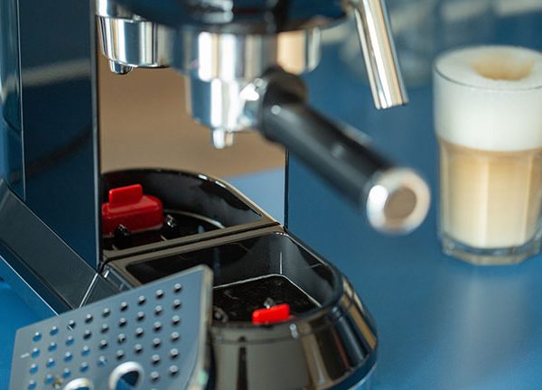 Nahaufnahme einer Smeg-Espressomaschine mit zwei Gl&auml;sern Latte Macchiato daneben.