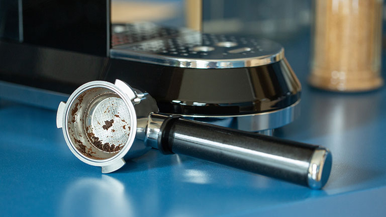 Espressomaschine entkalken Der herausgenommene Siebträger bei einer Smeg-Espressomaschine.