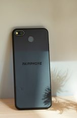Das Fairphone 3+ lehnt mit dem Display voran an einer Wand.