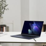 Ein aktuelles Galaxy Book Pro steht auf einem Tisch, daneben sind Notizbl&ouml;cke und eine Brille zu sehen.