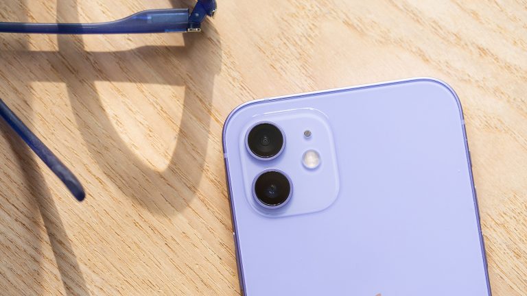 Nahaufnahme eines violetten iPhone 12. Zu sehen ist die Rückseite mit der Dualkamera und dem Blitz.