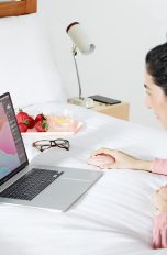 Eine Person nutzt eine Logitech MX Anywhere 3 an einem Laptop auf dem Bett.