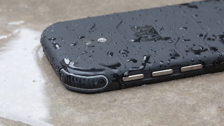 Das Outdoor-Smartphone Cat S42 liegt mit dem Display nach unten auf einem nassen Boden.