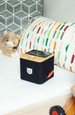 Eine schwarze Tigerbox Touch steht auf einem gemachten Kinderbett.