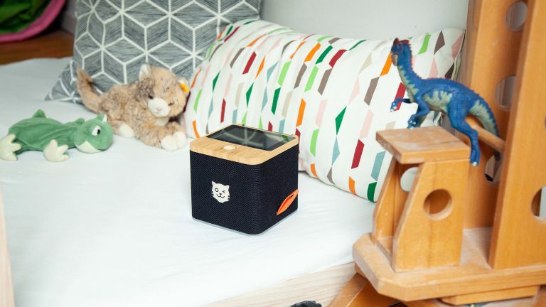 Eine schwarze Tigerbox Touch steht auf einem gemachten Kinderbett.